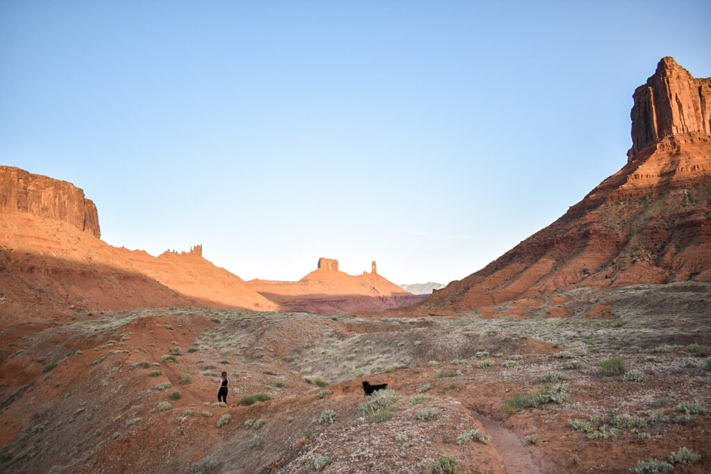 A woman and dog hiking in Castle Valley near Moab, Utah.