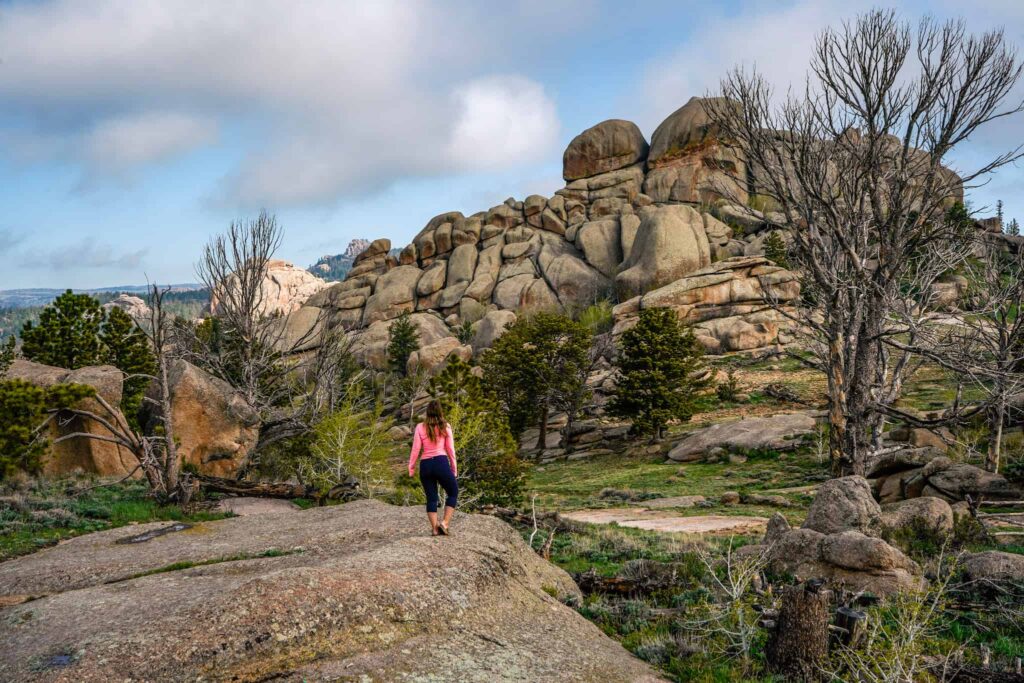 Woman stands in front of a rock formation in Wyoming.